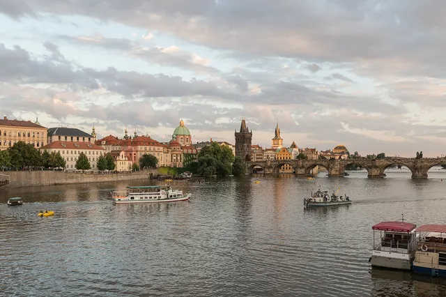 Charles Bridge stretching across the Vltava in Prague with its Gothic towers and boats on the river