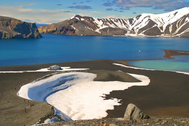 The caldera of Deception Island with dark volcanic beaches, snow and the bay of Port Foster