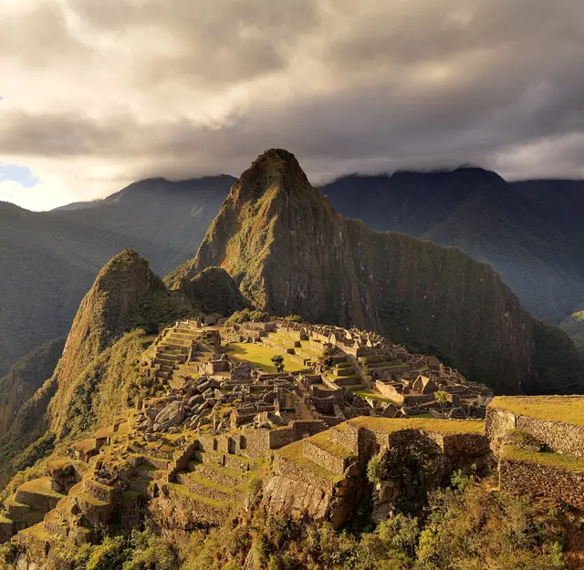 The Inca terraces and stone buildings of Machu Picchu with the peak of Huayna Picchu behind