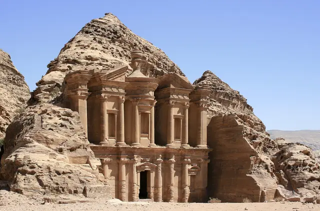 The huge rock-cut façade of the Monastery (Ad Deir) at Petra under a clear blue sky