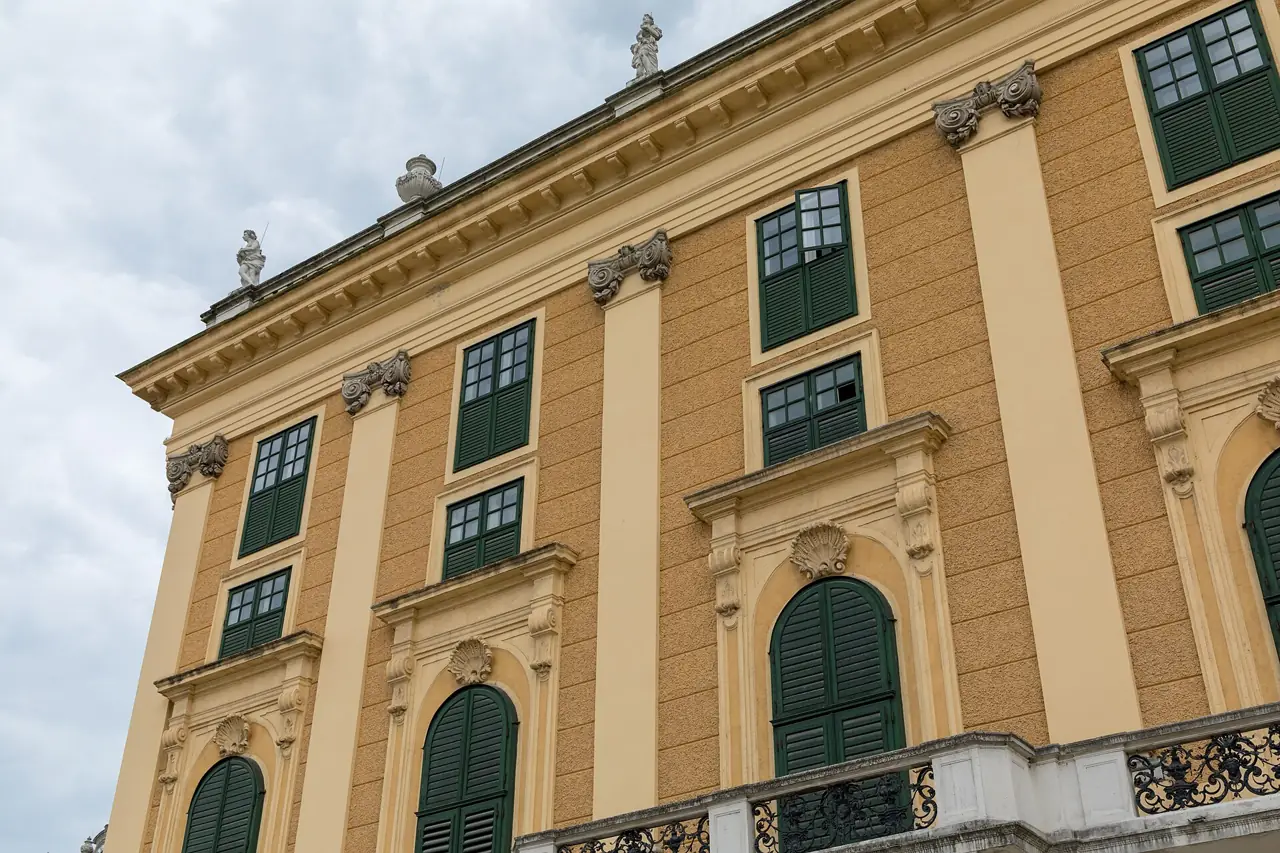 The yellow façade of Schönbrunn Palace with tall green-shuttered windows