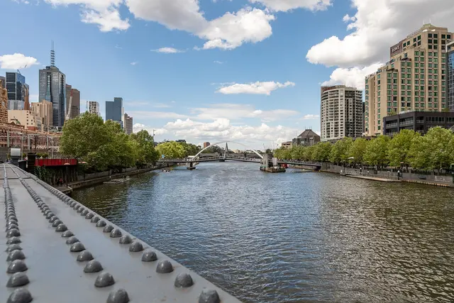 The Yarra River in central Melbourne, with city towers on one bank and Sandridge Bridge in the distance