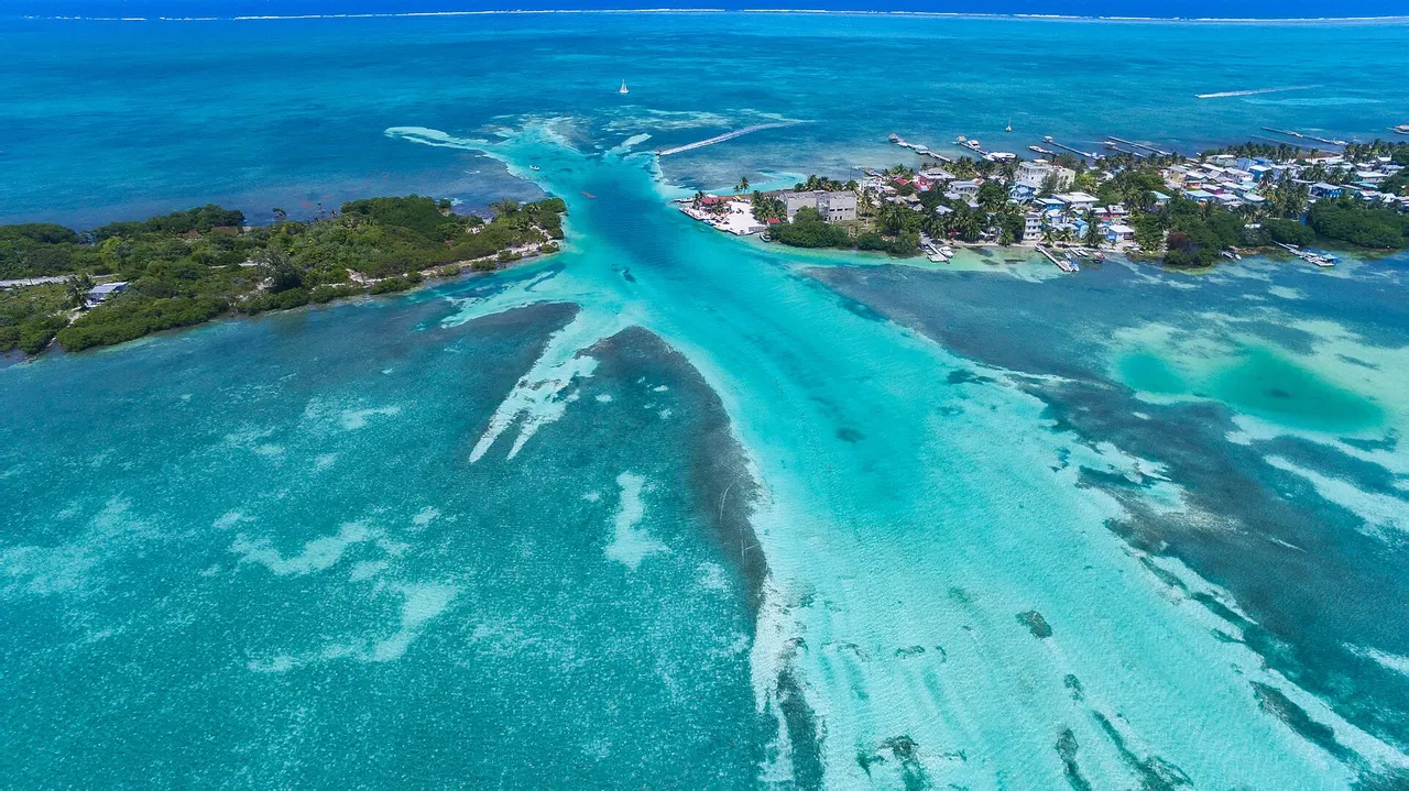 Aerial view of Caye Caulker and the turquoise channel known as the Split, surrounded by shallow reef water