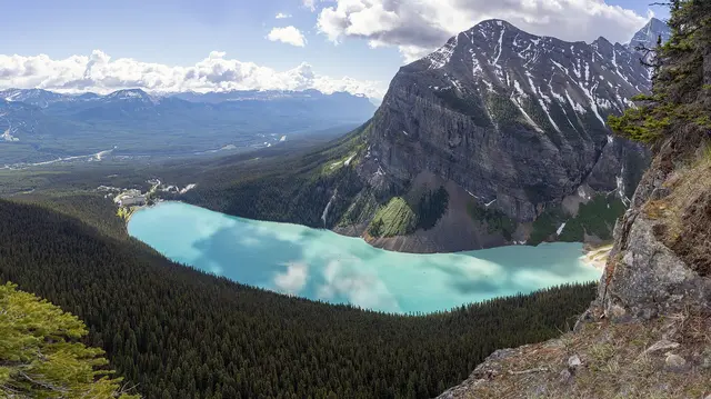 Turquoise Lake Louise below forested slopes and rocky peaks in Banff National Park