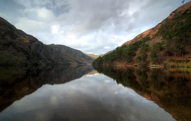 The Upper Lake at Glendalough in the Wicklow Mountains, reflecting the steep wooded hills around it
