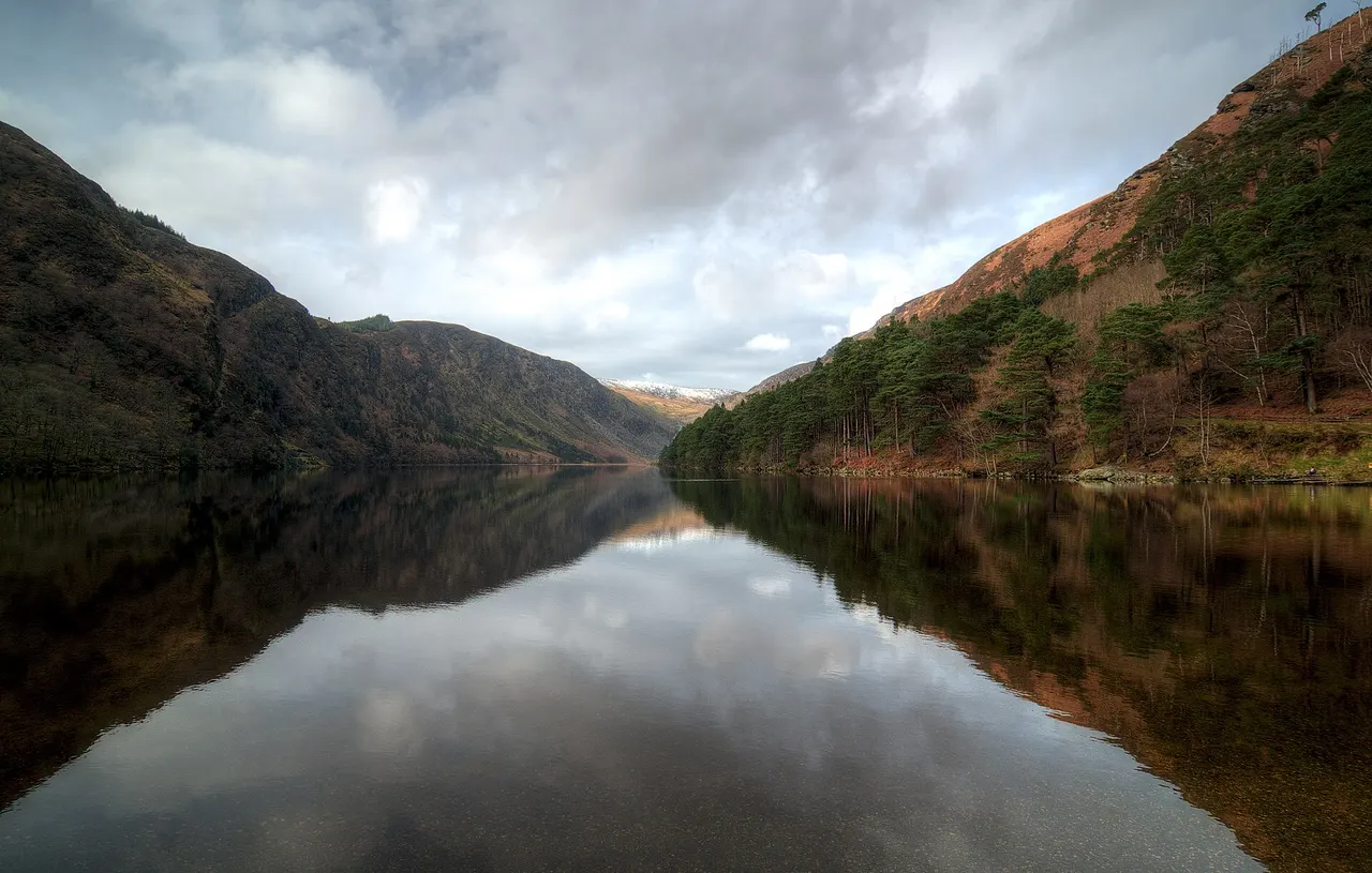 The Upper Lake at Glendalough in the Wicklow Mountains, reflecting the steep wooded hills around it