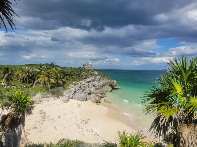 The Maya ruins of Tulum on a clifftop above a white-sand beach and turquoise Caribbean sea