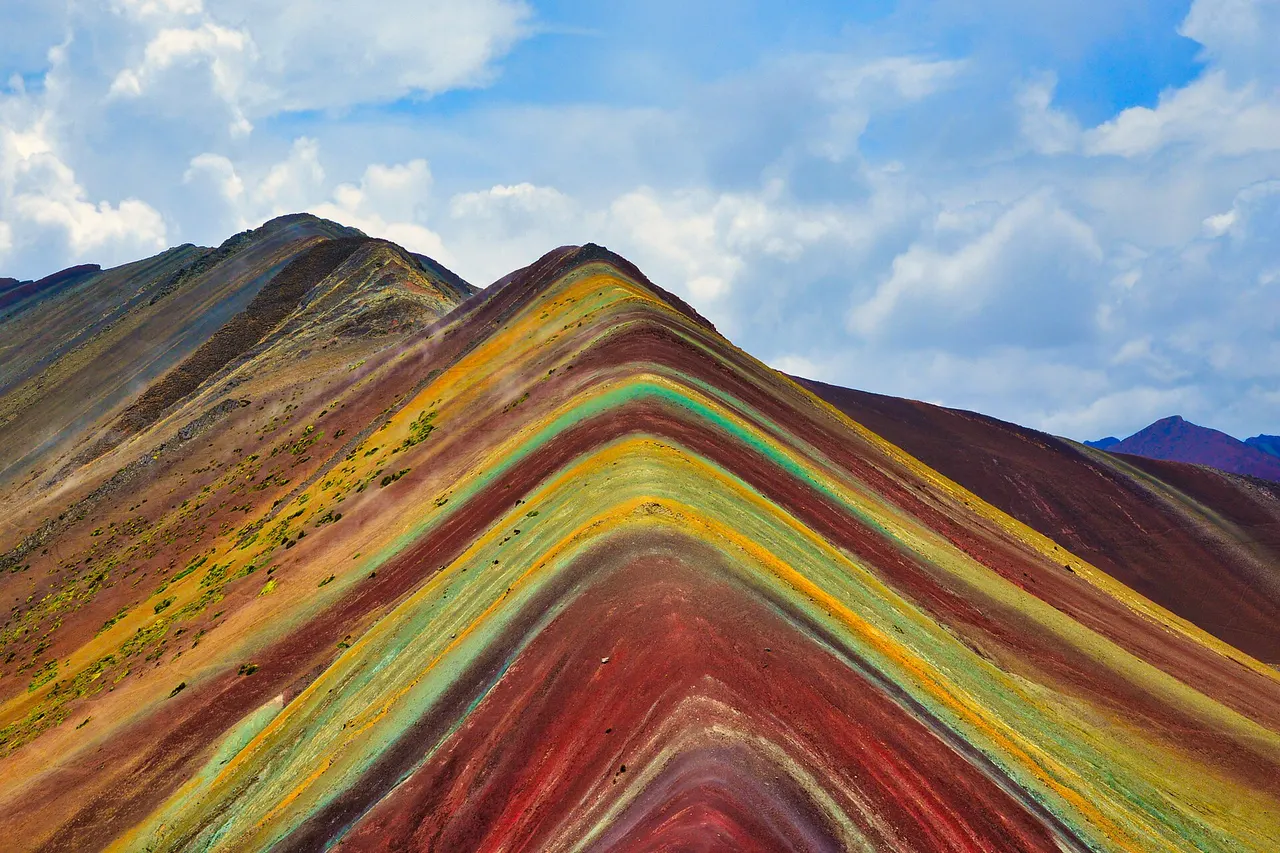 The striped red, yellow and green slopes of Vinicunca, the Rainbow Mountain, in the Peruvian Andes near Cusco