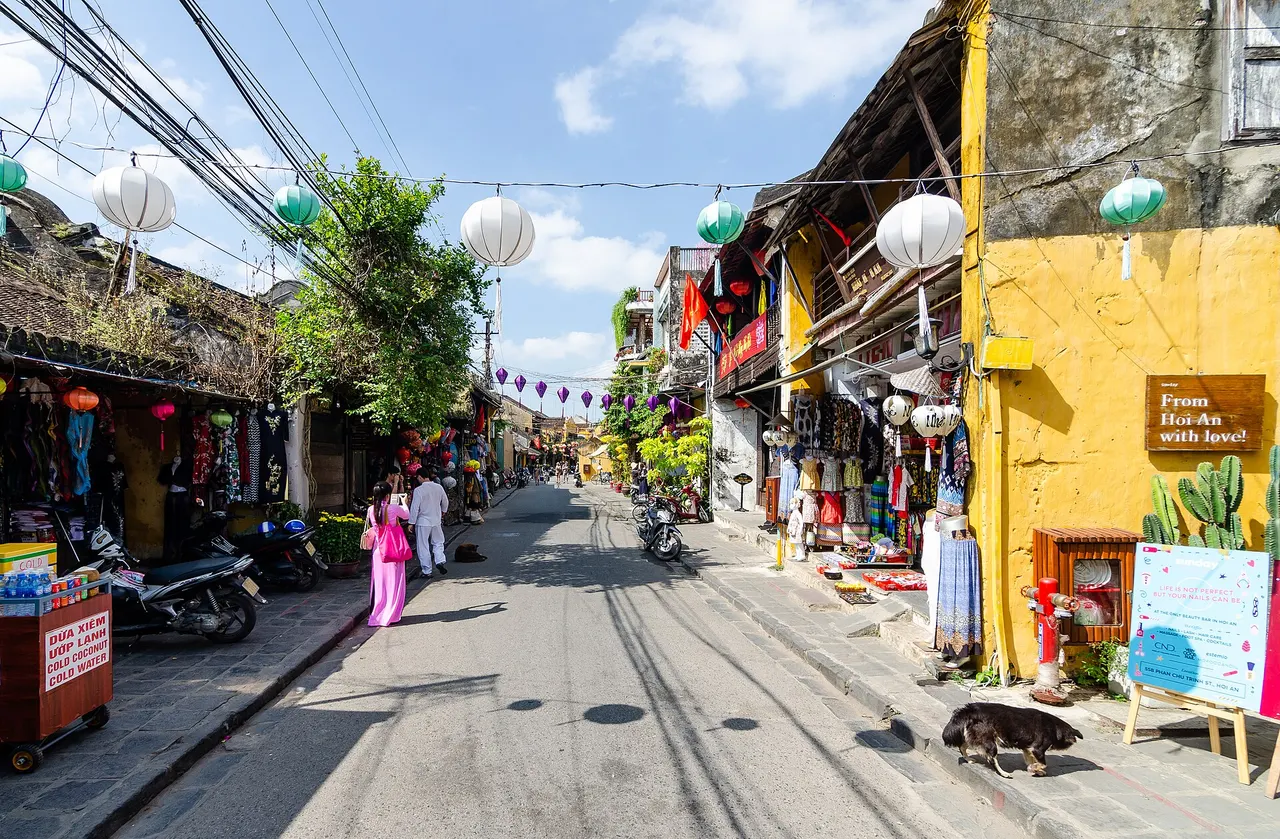 Lanterns strung across a street of yellow-walled shophouses in the Ancient Town of Hoi An, Vietnam