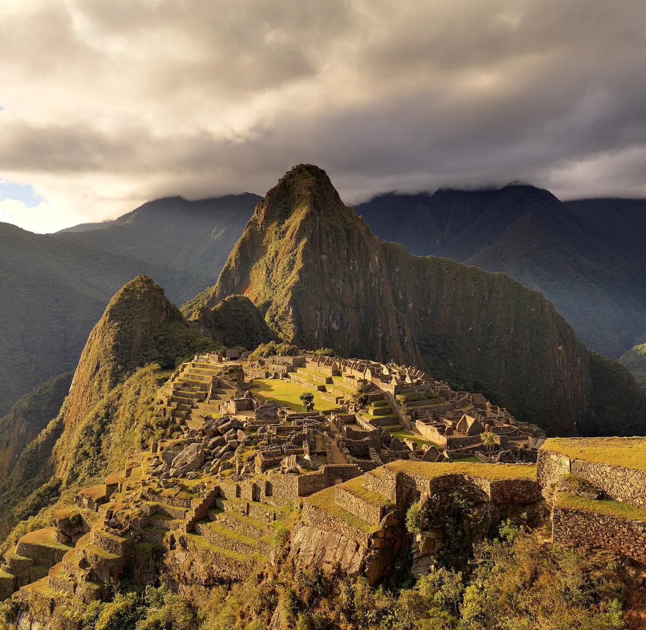 The Inca terraces and stone buildings of Machu Picchu with the peak of Huayna Picchu behind